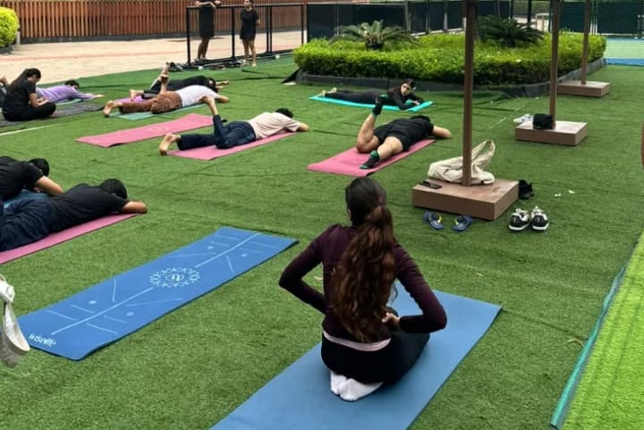 Founders doing yoga on mats on an outdoor lawn